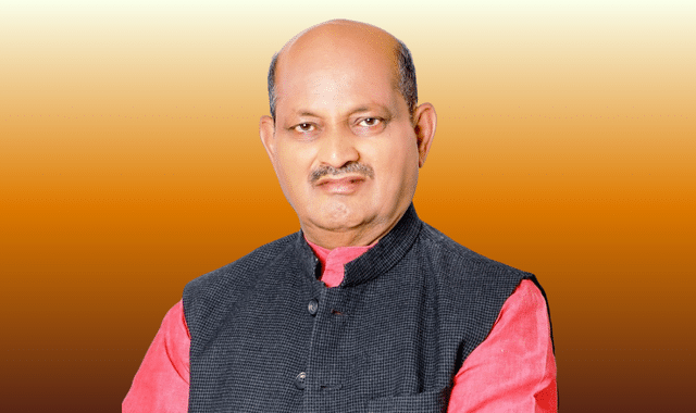 Studio portrait of Manmohan Samal in a dark waistcoat over a pink kurta.