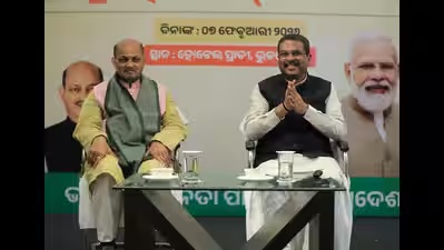 Manmohan Samal seated on stage beside Union Minister Dharmendra Pradhan at an event in Bhubaneswar.