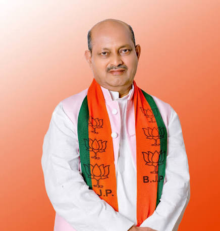 Portrait of Manmohan Samal wearing a white kurta and a Bharatiya Janata Party scarf.