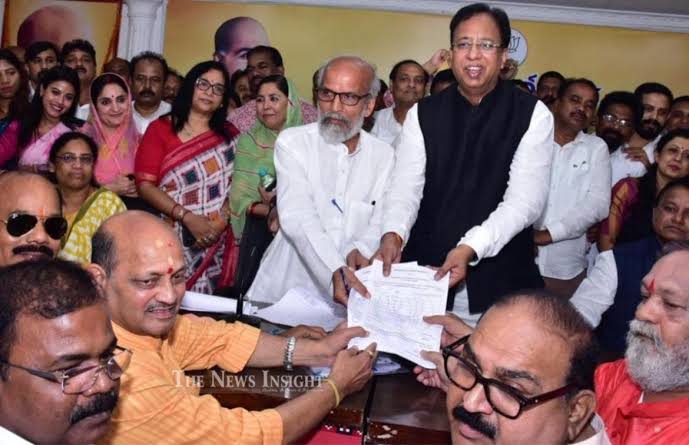 Manmohan Samal, seated at the left of a crowded room, as nomination papers are handed across a table during a party organisational election.