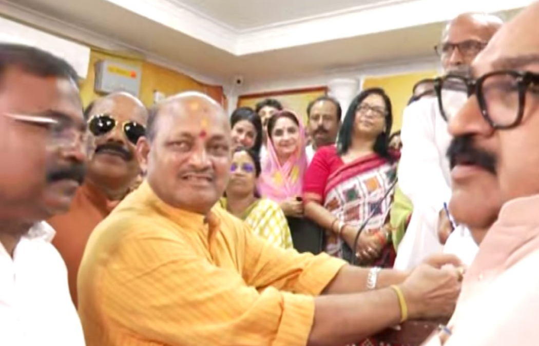 Manmohan Samal being greeted by colleagues in a crowded room after his re-election as state president.